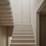 Cast concrete stair in a top-lit void, raking light picking out the edge of each tread and the folded underside of the flight