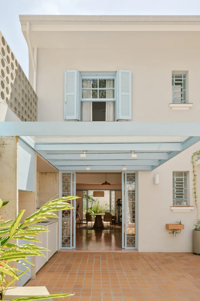 BF2 House by Peninsula Arquitetura, cream facade with light blue shutters and steel pergola