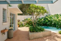 Planter, pool and pale blue metal roof in the courtyard of BF2 House