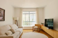 Living room with restored wood block flooring at BF2 House by Peninsula Arquitetura