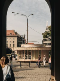 Chleboteka Okraglak framed by an arch across the square