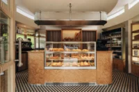 The sales counter and pastry case inside Chleboteka Okraglak by CUDO
