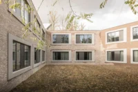 The brick courtyard under fallen leaves at College Cardinal Mercier