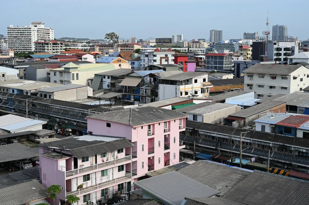 Aerial view of a dense neighbourhood of low-rise apartment and commercial buildings with a patchwork of rooftops