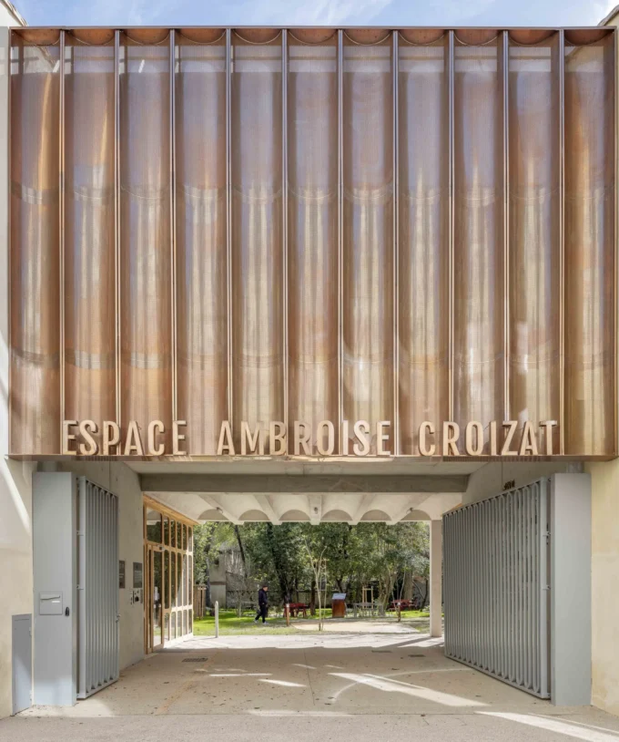 The street porch and copper sign of Espace Ambroise Croizat by TAUTEM Architecture