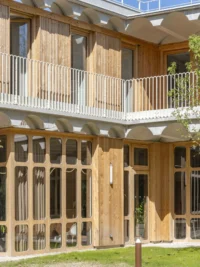 The courtyard and its timber balcony at Espace Ambroise Croizat