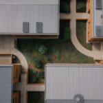 Aerial view of a low building whose separate wings wrap a planted central courtyard