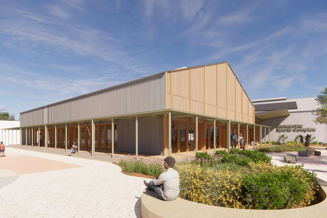 Rendering of a low metal-clad building with timber accents, a courtyard and seating area, and signage reading Sports, Brewarrina Multipurpose Sports Centre