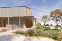 Rendering of a corrugated metal and timber building with a covered walkway and native garden beds