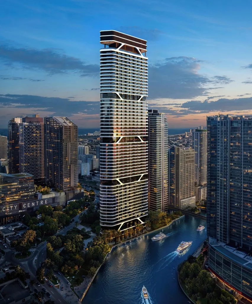 Skyscraper in cityscape with river and boats at sunset