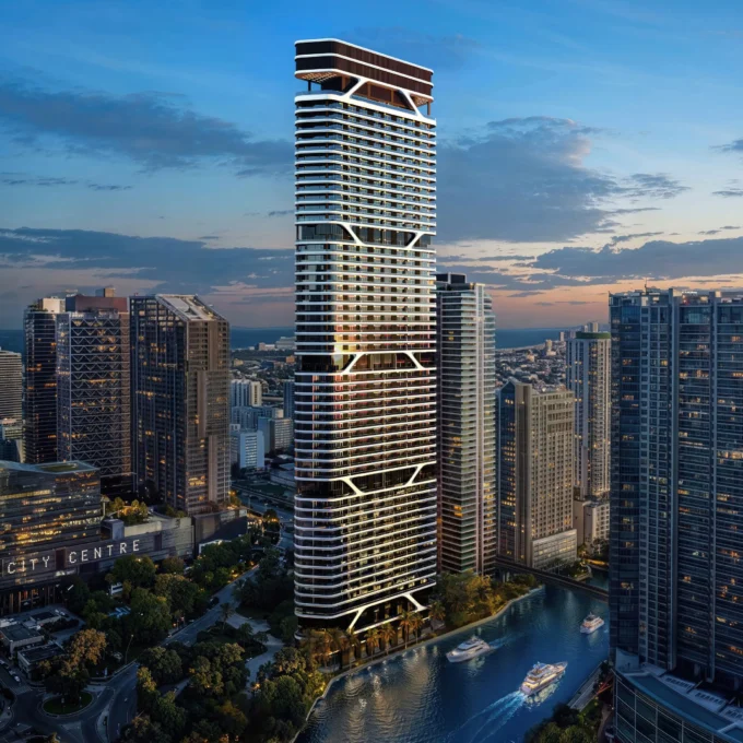 Tall skyscraper in cityscape with river and boats at dusk