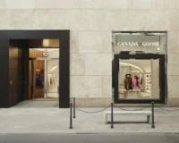 The preserved stone facade with a black framed shopfront and the brand sign above