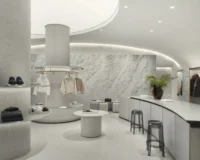 The textured white wall with plants, service counter and stools alongside