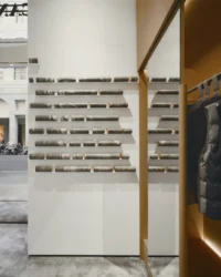 Accessory wall of slotted shelves in a walnut frame with the window beyond