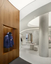 Blue parka in a walnut niche beside the curved white ceiling