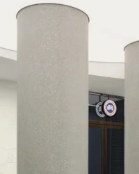 Close view of a terrazzo column beside a wall mounted brand plaque