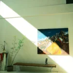 Daylit gallery room hung with large abstract paintings and a sculpture on the floor