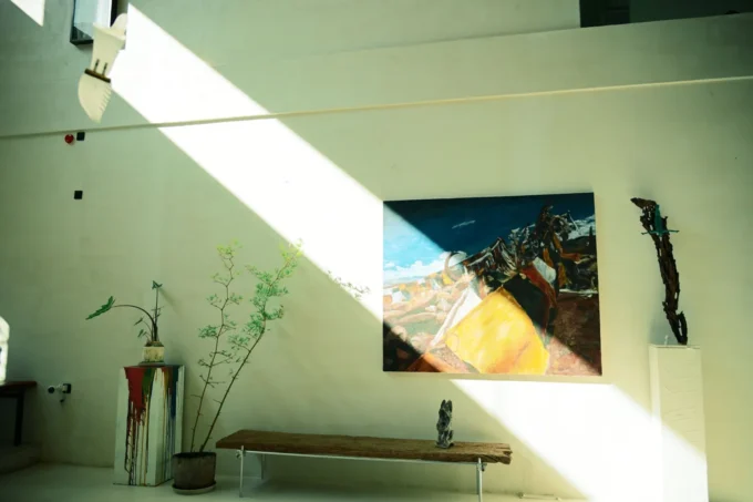 Daylit gallery room hung with large abstract paintings and a sculpture on the floor