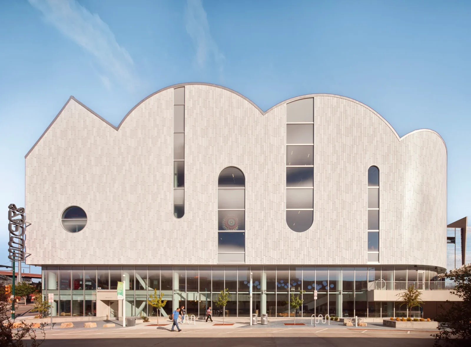 White barrel vaults with arched openings rising above a glazed ground floor