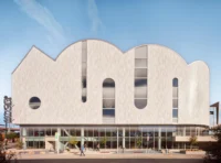 White barrel vaults with arched openings rising above a glazed ground floor