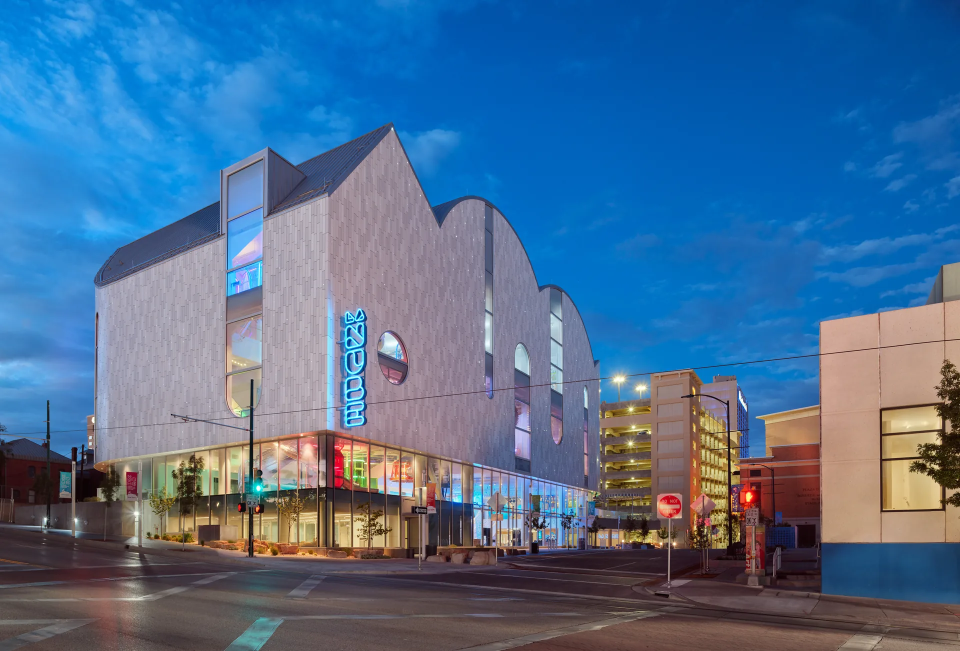 The museum lit at dusk on its street corner in the downtown grid