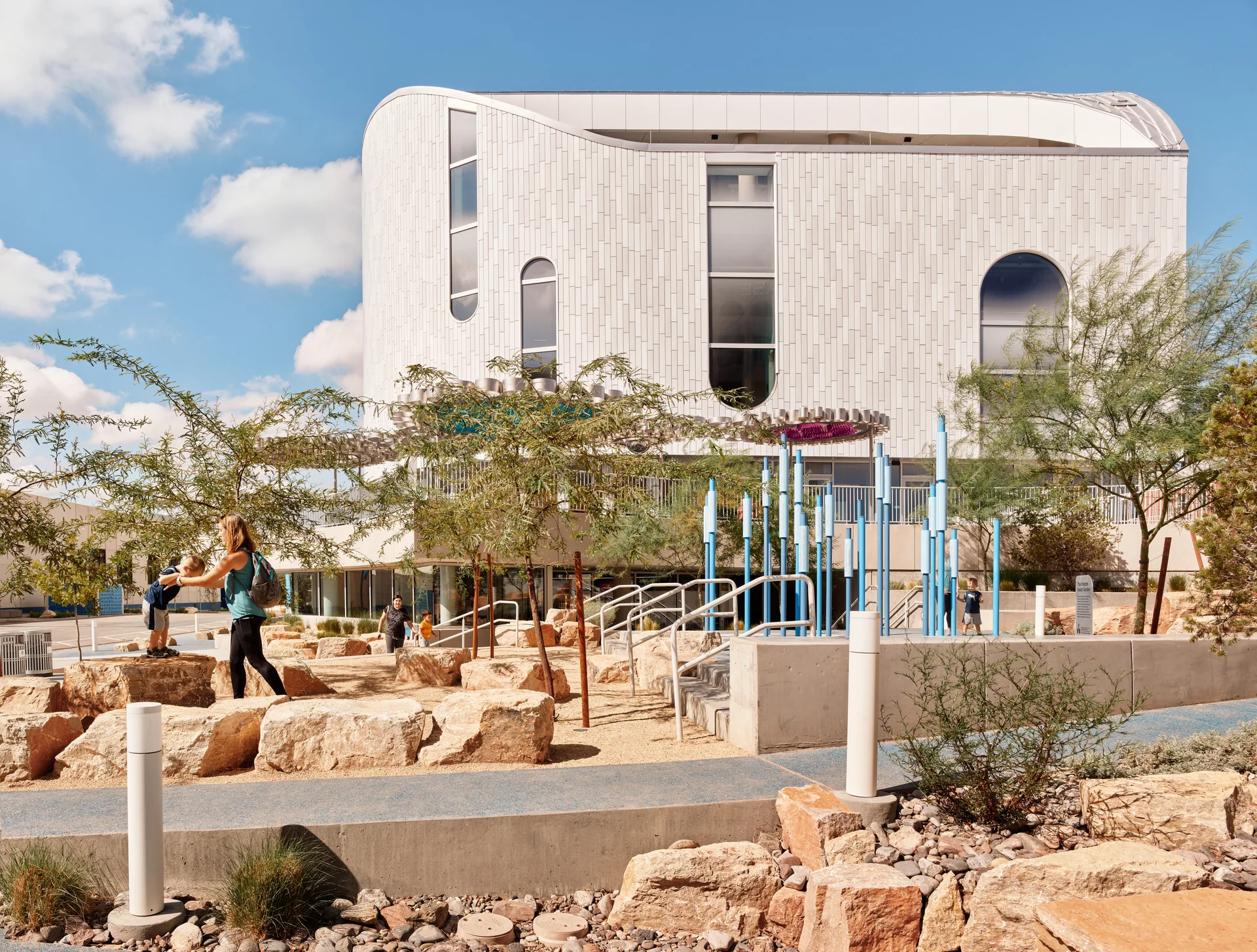 The plaza planted with desert species and rocks in front of the building