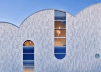 Close view of the vaulted facade with a tall arched window cut into it