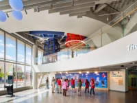 Interior with a curved balcony overlooking children gathered on the level below