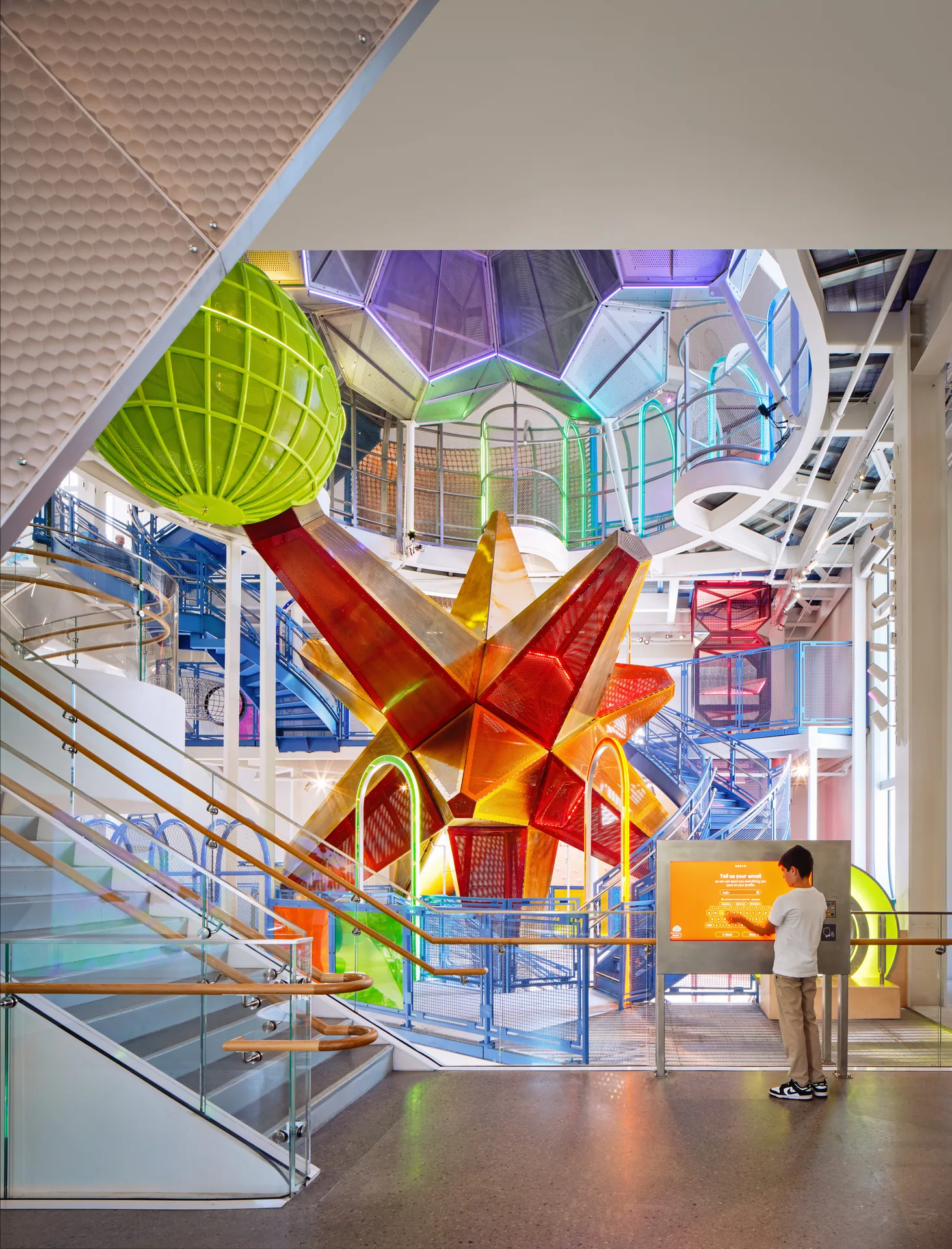 The atrium with green climbing pods and stairs threading between them