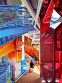 The climbing structure seen from below in red and orange steel and mesh