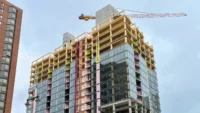 Ascent in Milwaukee under construction, a mass timber tower with exposed glulam floors, concrete cores and a crane