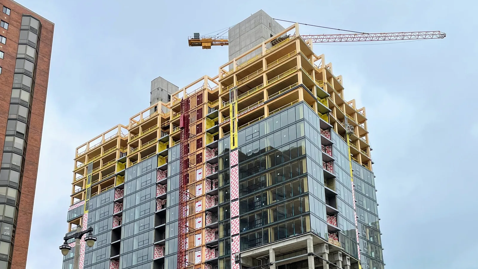 Ascent in Milwaukee under construction, a mass timber tower with exposed glulam floors, concrete cores and a crane