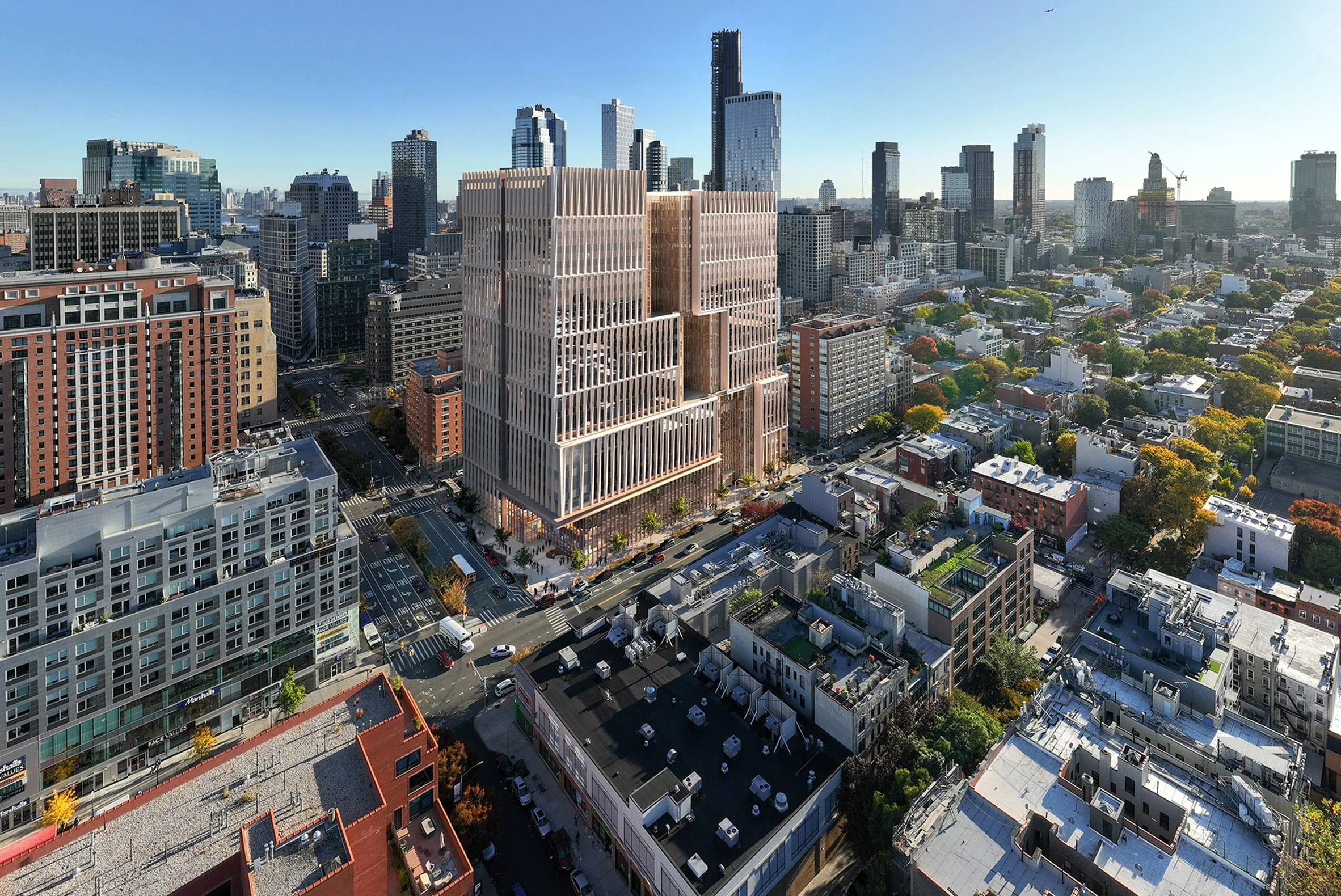 Aerial view of a stepped high-rise with slatted facades surrounded by rooftops and city towers