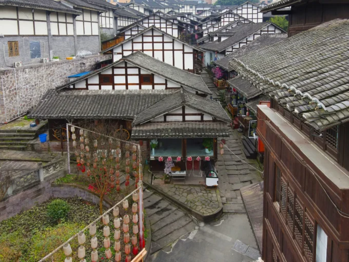 Traditional Chinese buildings with tiled roofs and lush greenery