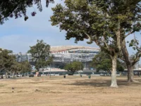 Lucas Museum of Narrative Art under construction in Exposition Park, Los Angeles, its curved white form seen from street level