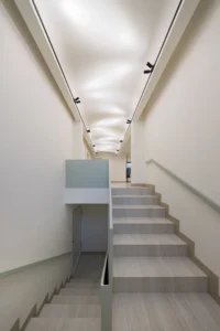 The stair beneath the curved reflective ceiling at Nafas-e-No Clinic