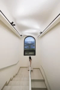 Stair rising toward the arched window at Nafas-e-No Clinic by Event Office