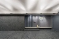 Concrete-walled entrance area at Nafas-e-No Clinic by Event Office