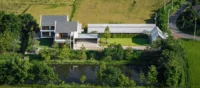 The pond and farm buildings of PIN'N PAN House by ForX Design Studio