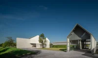 The long low wing and gabled end of PIN'N PAN House by ForX Design Studio