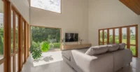 The living area opening to the green at PIN'N PAN House by ForX Design Studio