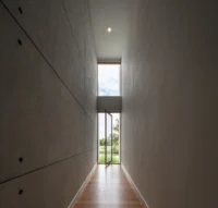 Concrete corridor with a slot view at PIN'N PAN House by ForX Design Studio