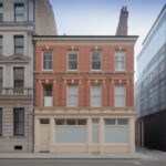 A classical stone facade, a red brick Victorian terrace and a modern glass building side by side