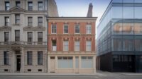 A classical stone facade, a red brick Victorian terrace and a modern glass building side by side
