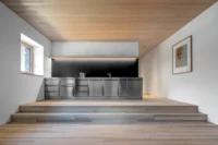 Kitchen raised on steps within an alpine loft at Vergalderie