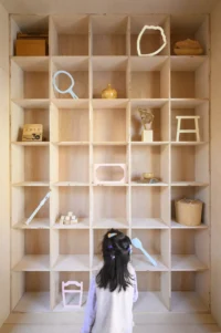 A child at the display shelving inside Wooden Wonders by MVRDV