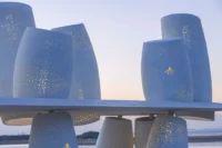 Close view of the glowing upper cylinders with starfish and octopus shaped openings, Seaside Swing Installation by XBTW OFFICE