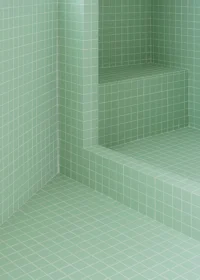Close view of a tiled bench and step forming a corner in the mint green bathroom, Aguacate Space by ALE Estudio