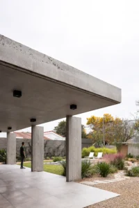 Underside of the thin concrete roof slab and columns at the corner of the covered terrace