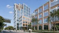 Glazed tower and gridded podium block seen from the pavement with young street trees, Greentown ThinkWorks